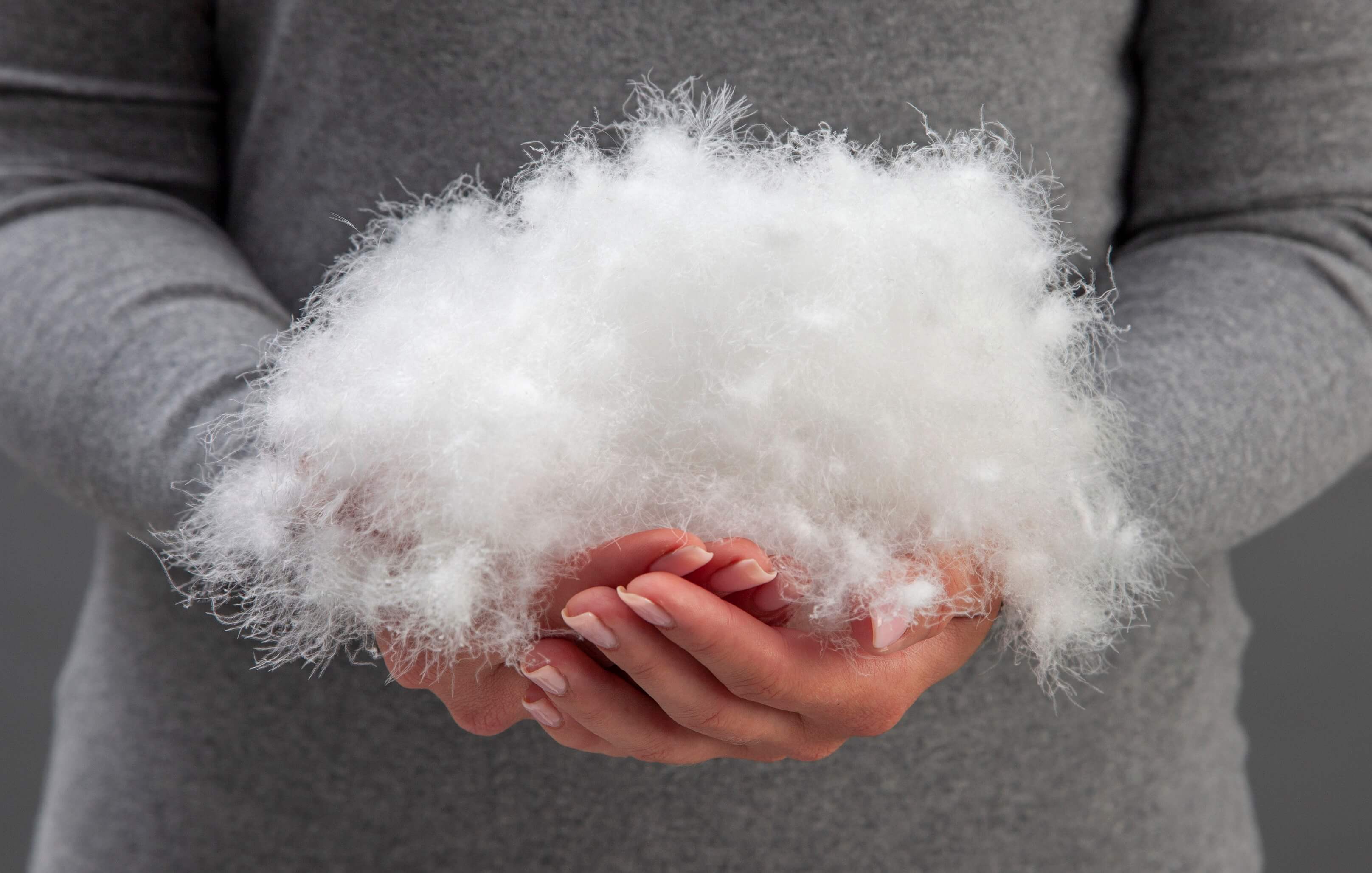 a person holding a pile of white fluffy cotton